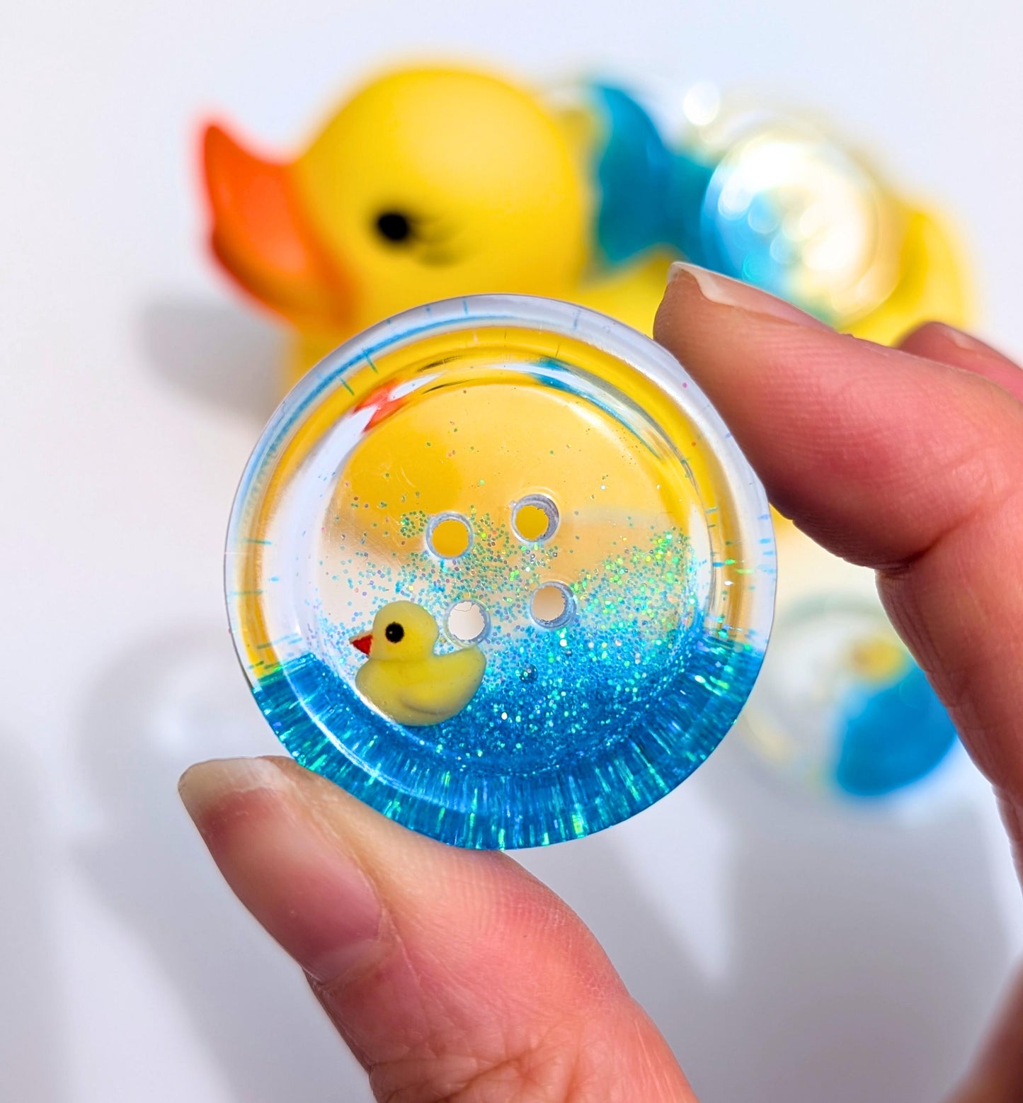 The Feeling Ducky Button – Sparkly Blue Transparent Resin Button with Floating Rubber Duck