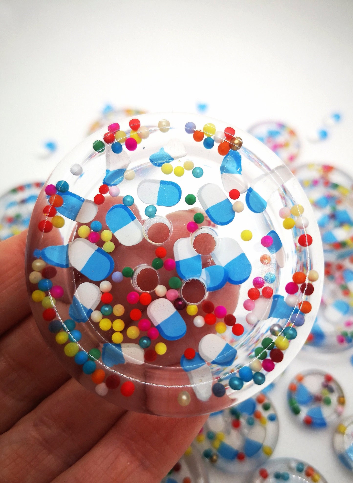 The Pharmacy. Clear handmade fake pill art buttons with rainbow dots